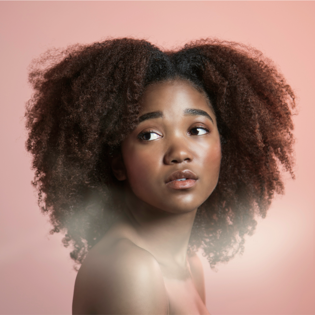 a portrait of a young Black woman on a pink background